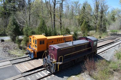 The two Museum's RS-4-TC locomotives, one orange and one maroon, sit on tracks at the Railway History Campus