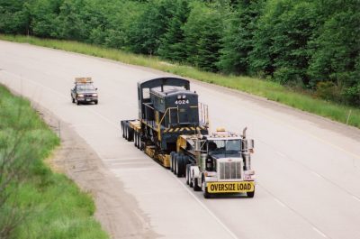 RS-4-TC locomotive 4024 loaded on a lowboy trailer travels down I-90 on Snoqualmie Pass towards North Bend, WA.