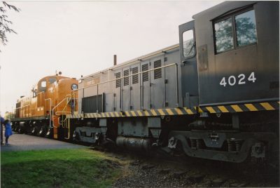 The Museum's former Alco RSD-4 coupled to RS-4-TC #4024 after unloading at North Bend. The fireman on #201 is looking backwards toward #4024. A young girl covers her ears on the depot platform.