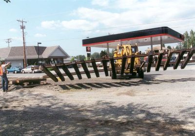 The Museum's 1979 Pettibone Speedswing moves a section of track into place before unloading RS-4-TC #4024. Behind the Pettibone is the North Bend Texaco station, today a Shell station.