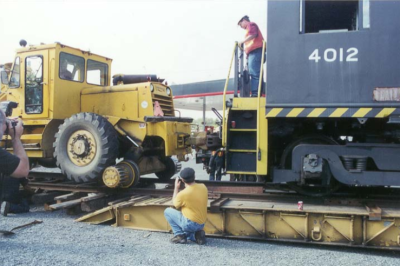 The Museum's 1979 Pettibone couples to RS-4-TC #4012 to pull it off the trailer. Various crew members assist.
