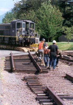 RS-4-TC #4012 sits on a lowboy trailer just east of the end-of-track in North Bend. Workers are preparing a section of track to connect the trailer to the mainline.